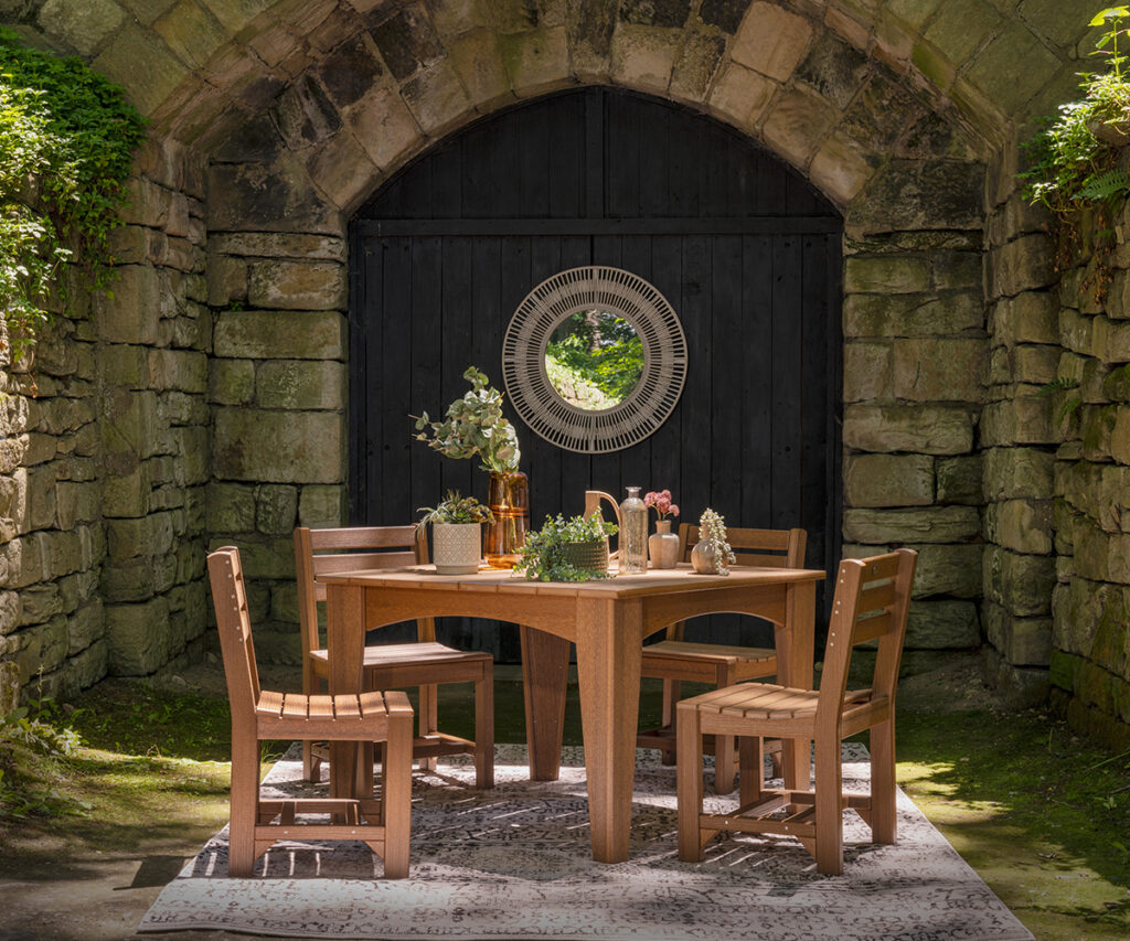 Outdoor furniture dining set beneath a stone archway